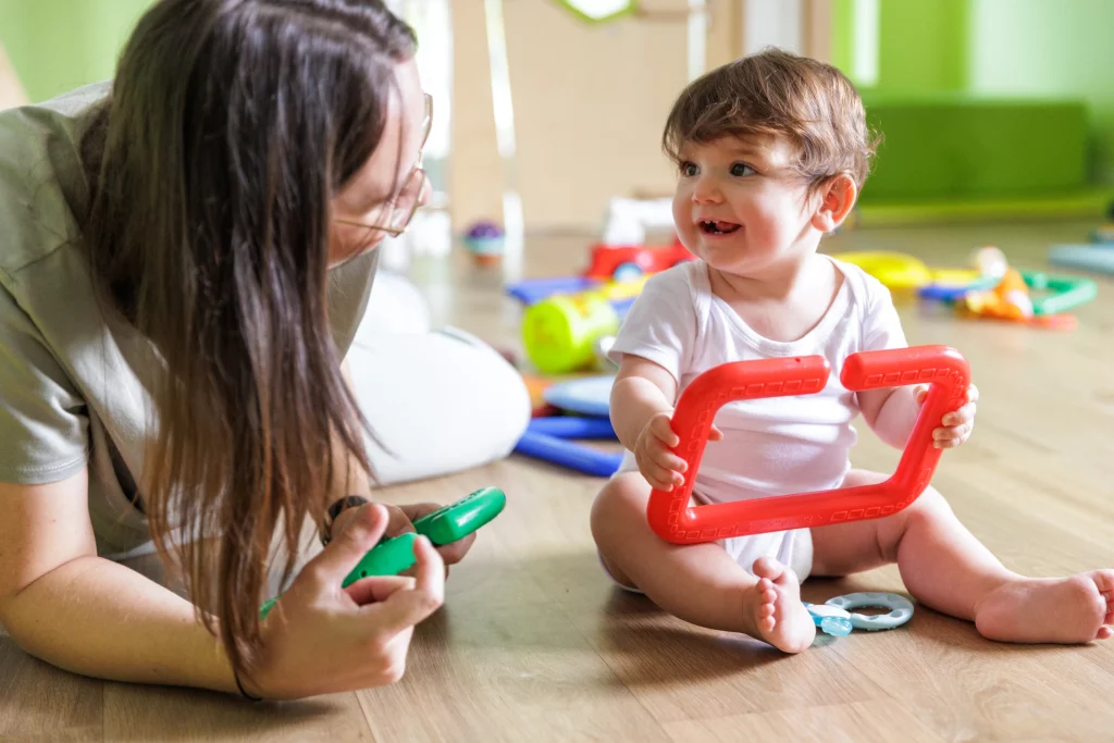 Une professionnelle partage un moment complice avec à un bébé dans une micro-crèche.