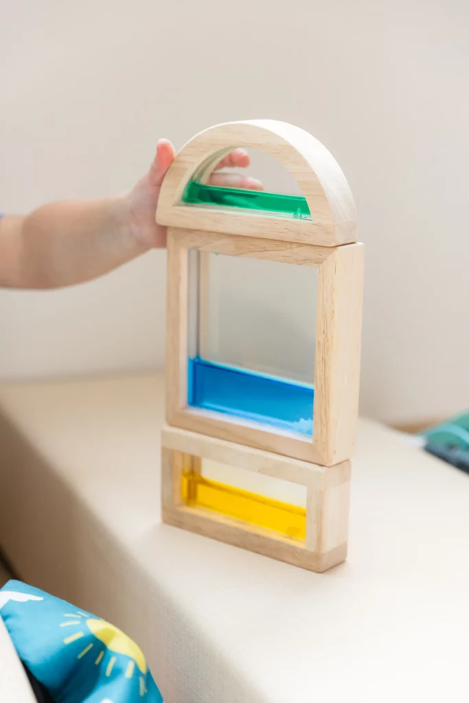 Une main d'enfant attrape un jeu d'éveil dans une micro-crèche.