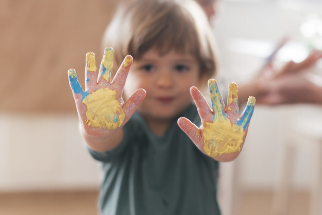 Enfant qui fait une activité manuelle dans une crèche les jeunes pousses